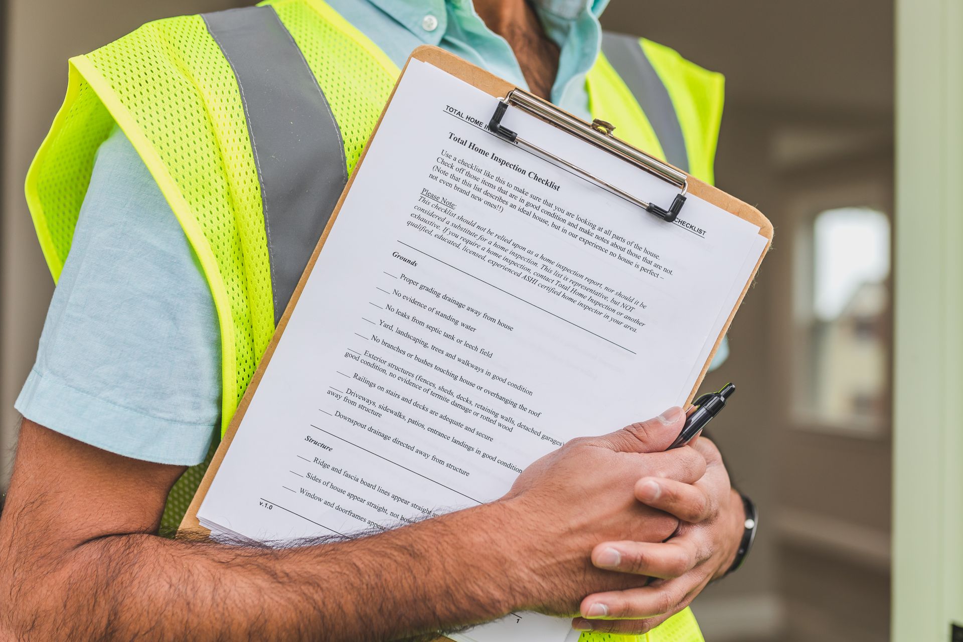 Inspector in a high-visibility vest holding a clipboard checklist