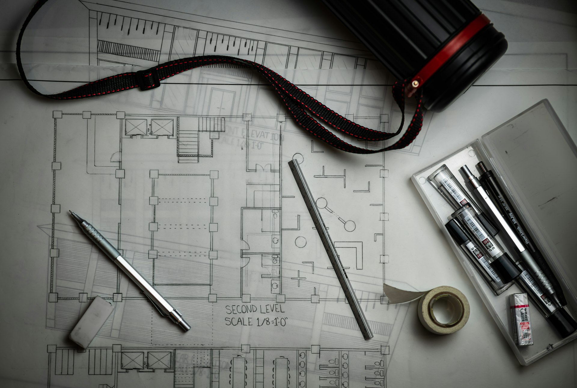 Architectural floor plans with drafting pencils and a ruler