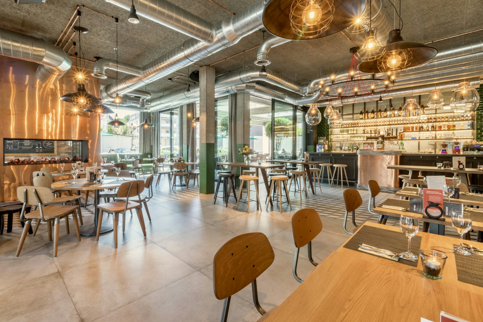 A restaurant dining room with set tables and a bar