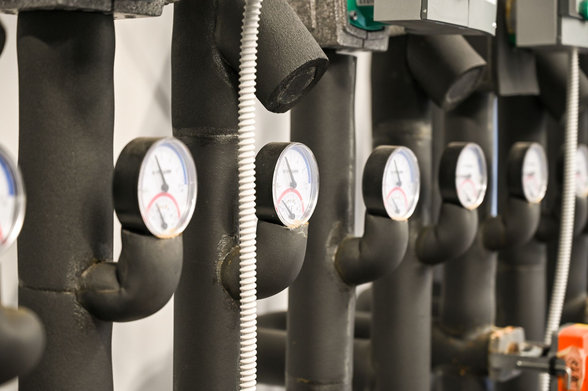 Insulated pipes with gauges in a building mechanical room