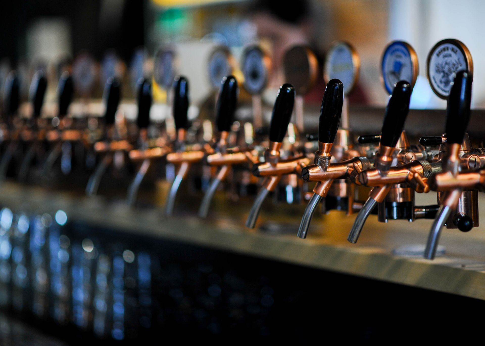 Row of copper beer taps on a bar counter