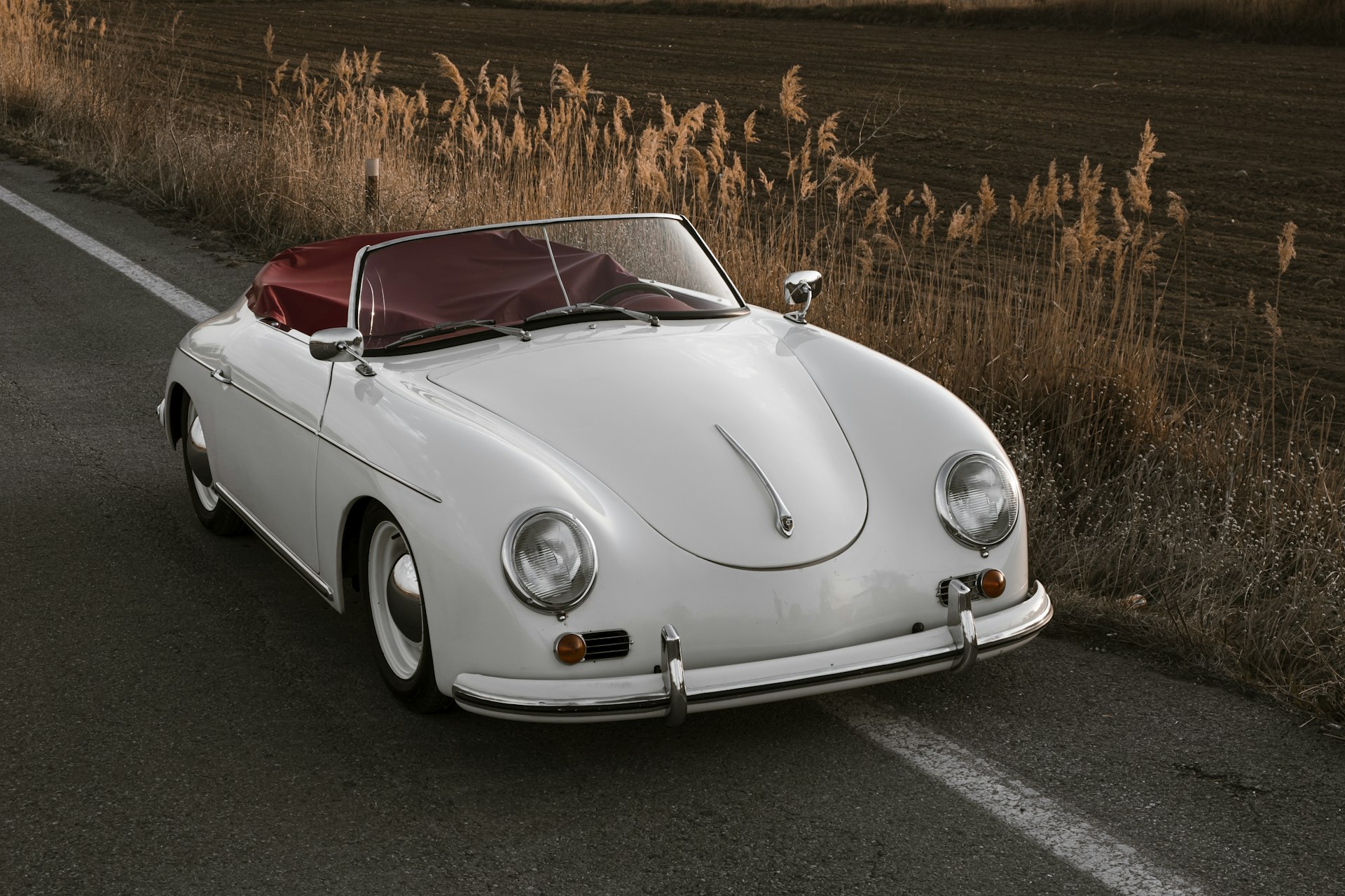 White classic convertible sports car parked on a country road