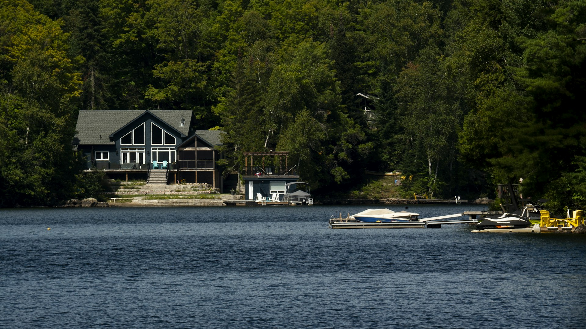 Lakeside cottage with a dock and boats in Ontario cottage country